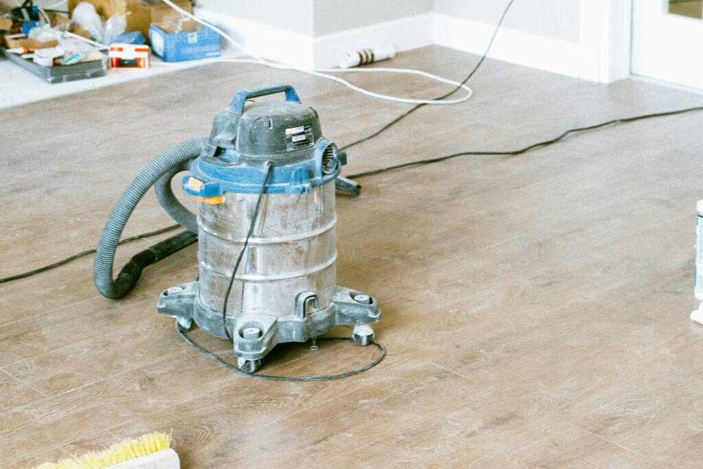 Vacuum and tools in a room undergoing renovation, showcasing home improvement.